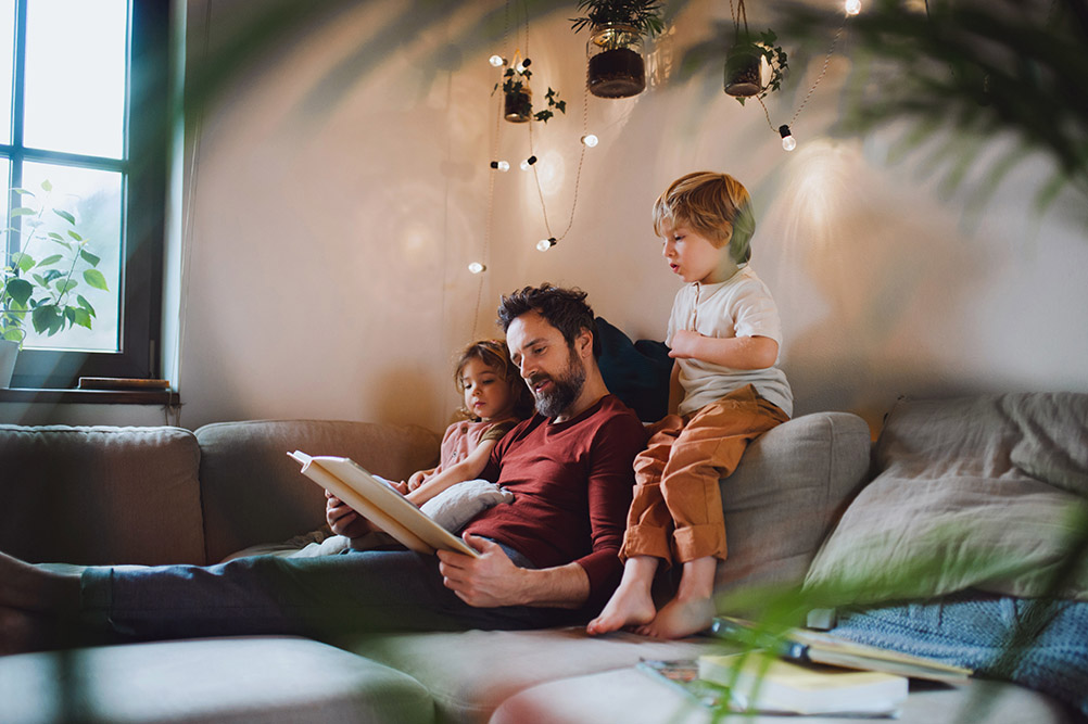 Mature father with two small children resting indoors at home, looking at photo album. Should I combine my pensions into one pot?